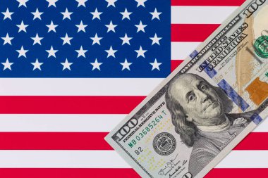 Amerika Birleşik Devletleri bayrağının arka planına karşı 100 Amerikan doları.