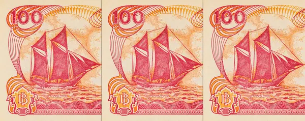 Endonezya 'dan gelen 100 rupiah banknotunun bir parçası, Pinisi Teknesi' ni resmediyor. Endonezya 'dan kağıt para.