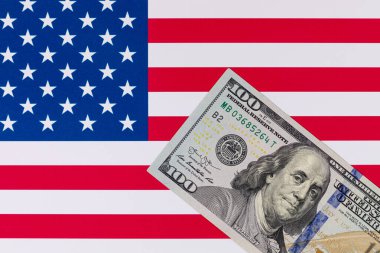 Amerika Birleşik Devletleri bayrağının arka planına karşı 100 Amerikan doları.