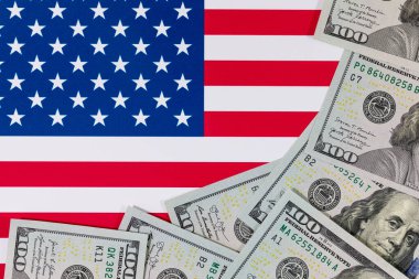 Amerika Birleşik Devletleri bayrağının arka planına karşı 100 Amerikan doları.