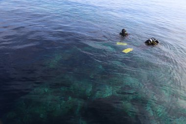 May 24, 2017 - Tuscany, Italy: two divers swimming on the surface of the water with the equipment