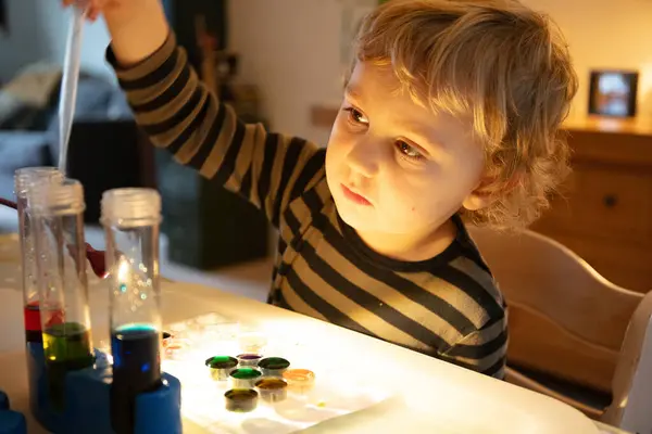 Educational home Learning with chemical experiment for a Caucasian child, with test tubes and paints