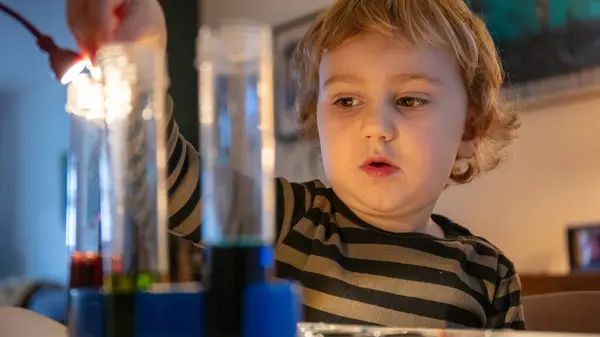 Educational home Learning with chemical experiment for a Caucasian child, with test tubes and paints