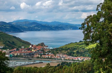 Kuzey İspanya 'nın tepeleri, dağları ve Atlantik Okyanusu kıyıları olan kayalık sahil manzarası, gökyüzü arka planı, Zumaia kasabası.