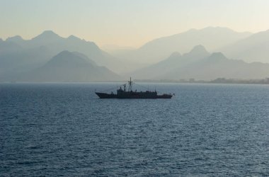 Türkiye askeri savaş gemisi gün batımında ve arkaplanda dağlar var