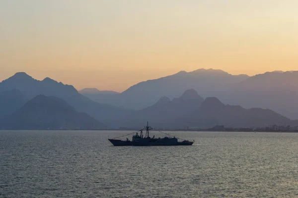 Türkiye askeri savaş gemisi gün batımında ve arkaplanda dağlar var