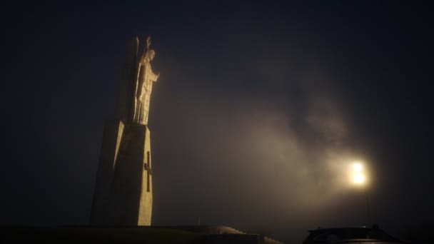 在浓雾中的耶稣基督的宏伟雕像 夜间被聚光灯照亮 — 图库视频影像