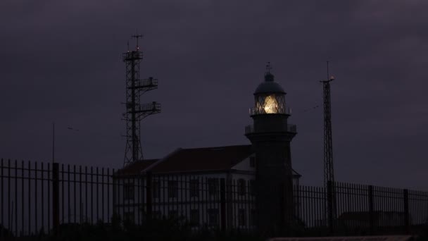 一个神秘的黑色灯塔在黄昏的时候在海滨发光 — 图库视频影像