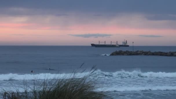 Kilka Osób Uprawia Surfing Oceanie Wieczorem Tle Tankowców Światłami Molo — Wideo stockowe