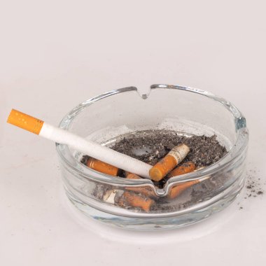 Beyaz arka planda kül tablası sigaraları izole.