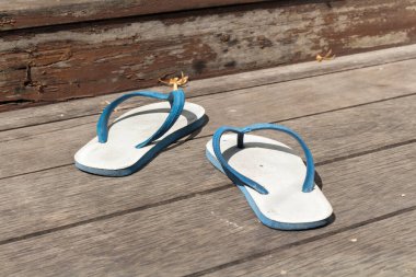 Evin dışındaki ahşap zeminde terlikler..