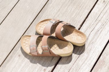 Deri sandaletler ahşap döşeme adamı.