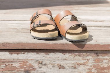 Deri sandaletler ahşap döşeme adamı.