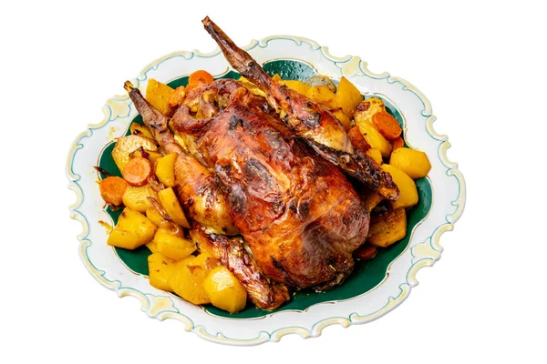 stock image Grilled whole guinea fowl or baked pearl chicken on roasted potatoes and vegetables and port wine sauce is served on a beautiful plate. Clipping path. Isolated on white.