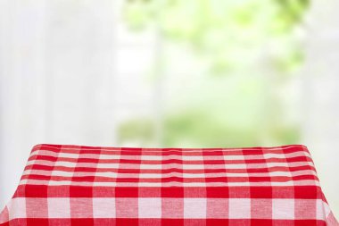 Boş masa ürünü. Boş bir kırmızı kareli masa örtüsünün ya da kırsal bir masanın üzerindeki peçetenin bulanık perde arka planına yakın çekim. Gıda ve ürün görüntüleme montajı şablonu.