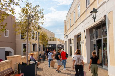 AGIRA, SICILY, İtalya - 30 SEP 2023. Sicilya Outlet Village alışveriş merkezi popüler bir ziyaretçi mıknatısıdır. Outlet Village 'da alışveriş yapan insanlarla geçiş.