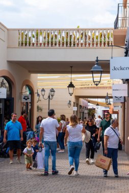 AGIRA, SICILY, İtalya - 30 SEP 2023. Sicilya Outlet Village alışveriş merkezi popüler bir ziyaretçi mıknatısıdır. İnsanlar Sicilya Outlet Köyü 'nden alışveriş yapıyor..