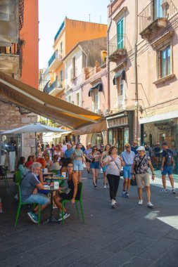 Taormina, Sicilya, İtalya - 28 Eylül 2023. Taormina 'nın işlek sokaklarındaki turistler kafelerde ve restoranlarda. Şehir manzaraları, cepheler, mimari ve en popüler sokaklar.