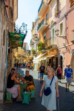 Taormina, Sicilya, İtalya - 28 Eylül 2023. Taormina 'nın işlek sokaklarındaki turistler kafelerde ve restoranlarda. Şehir manzaraları, cepheler, mimari ve en popüler sokaklar.