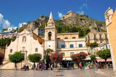 Sicilya, Taormina, İtalya - 28 Eylül 2023. Şehir manzarası, cephesi, mimarisi ve en popüler caddeleri. Mainsquare Piazza IX Aprile ve San Giuseppe kilisesinde turistler.