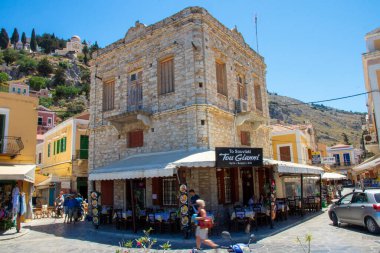 SYMI, Yunanistan - 03 Haziran 2021. Turistlerin kaldığı liman yakınlarındaki Surmi kasabasında bir lokanta. Tüm Ege 'deki en güzel ve romantik bölge..