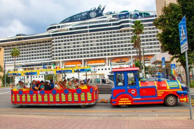 Sicilya, Messina, İtalya - 26 Sep 2023. Bir tren Sizilia 'daki Messina limanından şehir turu için turist alıyor. Arka planda, yolcu gemisi Msc World Europa.