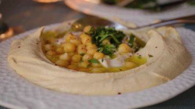 Nohut çerezi humusu ve bir parça pide ile bir el..