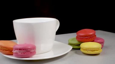 Siyah bir arka planda tatlı ve renkli Fransız kurabiyeleri..