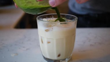 Buzlu yeşil kibrit sütlü çay ve bardağa doldurulmuş süt.