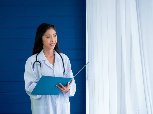 Χαμογελώντας Όμορφη Ασιάτισσα Γιατρός Πορτρέτο Στέκεται Μπλε Ξύλο Και Λευκό — Φωτογραφία Αρχείου