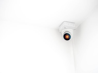 Beyaz güvenlik kamerasındaki dijital göz teknolojisi ya da beyaz duvar binasının arka planındaki tavan arasında fotokopi alanı ile çalışan güvenlik kamerası ya da gözetim..