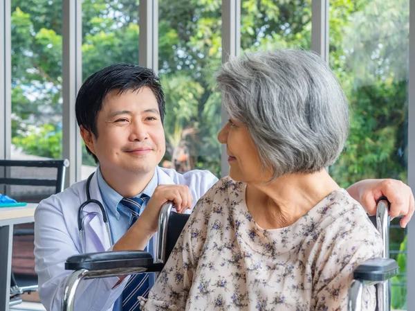 Χαμογελαστός Θετικός Ασιάτης Γιατρός Λευκό Παλτό Μιλά Φροντίδα Ηλικιωμένη Ηλικιωμένη — Φωτογραφία Αρχείου