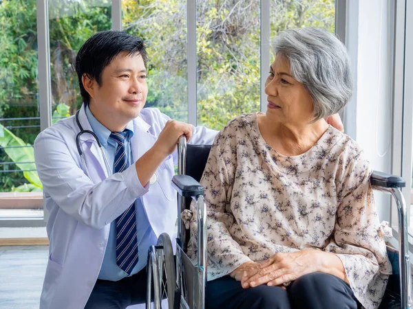 Uśmiechnięty Azjata Lekarz Białym Płaszczu Rozmawia Pacjentką Podeszłym Wieku Która — Zdjęcie stockowe