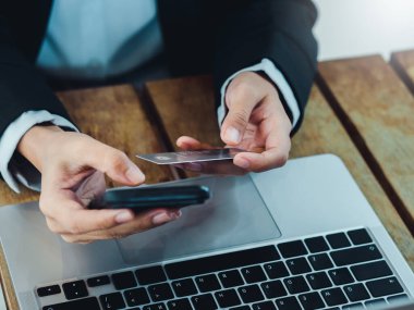 Güvenli ödeme konsepti. Çevrimiçi alışveriş, dijital bankacılık işlemleri ve finans uygulamaları için cep telefonu alımı kullanarak iş adamlarının kredi kartı üzerindeki koruma kalkanı simgesi.