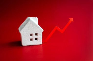 Ev vergisi, ekonomik büyüme, gayrimenkul değeri, sigorta hizmetlerinin fiyatı, gayrimenkul piyasası enflasyon kavramları. Artan ok grafiği ve kırmızı zemin üzerinde beyaz minyatür ev modeli.