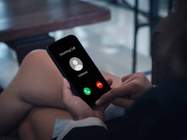 Incoming call with unknown caller, malicious phone calls concept. Unknown number displayed showing on smart mobile phone in business person hand. Spam and robocalls, scam call alert.