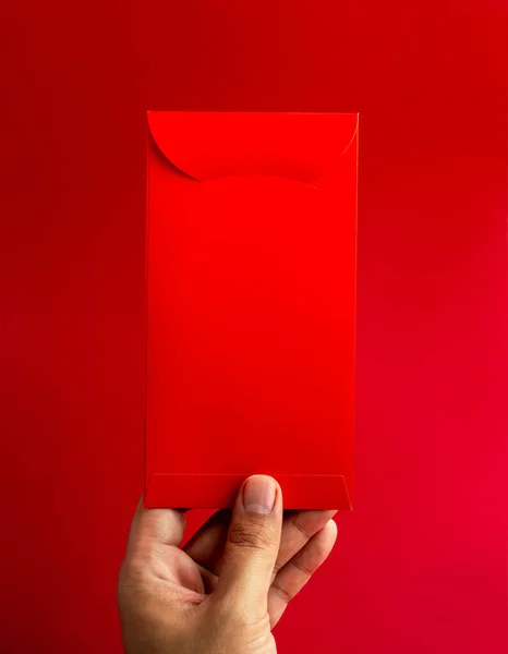 Красный Конверт Держащийся Вручную Изолирован Красном Фоне Вертикальный Стиль Hongbao — стоковое фото