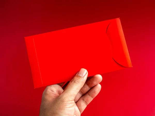 Red Envelope Vertical Style Holding Hand Isolated Red Background Hongbao Stock Photo