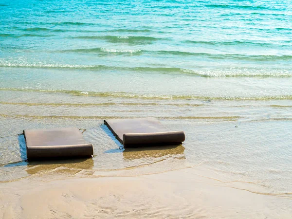 两个空荡荡的日光浴座椅在清澈的蓝水海浪和沙滩背景上 没有人 晴天在海景背景下放松双人床 — 图库照片