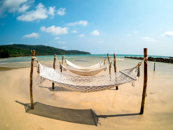三根空的绳子摇篮挂在沙滩上的木杆上 海岛蓝天背景 在阳光普照的日子 在没有人的情况下放松吊床或摇床 — 图库照片