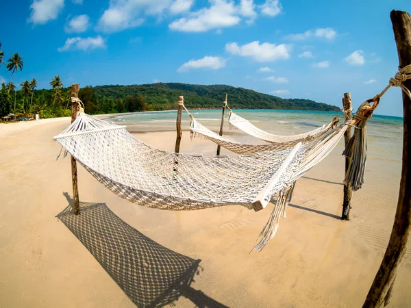 三根空的绳子摇篮挂在沙滩上的木杆上 海岛蓝天背景 鱼眼尽收眼底 在阳光普照的日子 在没有人的情况下放松吊床或摇床 — 图库照片