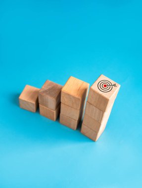 Hedef ve başarı. Ok dartı, tahta küp blokların tepesindeki hedef simgesi, bar grafik adımları, dikey stil. İş büyüme süreci, kalkınma, liderlik, pazarlama, ekonomik iyileştirme kavramları.