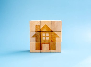 Emlak yatırımı, emlak finansmanı, tasarruf ve satın alma, ev yapımı ve ipotek konseptleri. Mavi arkaplanda ev simgesi olan tahta kübü blok bulmacası, en düşük biçim.