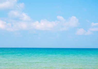 Güneşli bir günde parlak deniz manzarası. Yaz arkaplanı tropikal manzara, berrak deniz suyu, beyaz bulut ve açık mavi gökyüzü güneş ışığı günü, yaz manzarası, tatil posterleri.