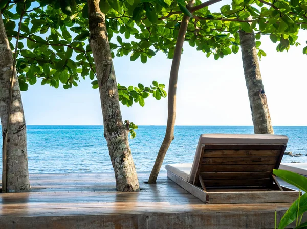 木制日光浴床的背面 床垫装饰在木制甲板平台上 海景景观与蓝色大海 树木和夏季日落天空背景与空间 假日旅行概念 — 图库照片