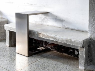 Beyaz terrazzo üst ve çelik yan sehpalı boş beton koltuk, beyaz grunge çimento arka plan, iç tasarım tavan arası tarzı güzel terrazzo fayans zemininde modern tasarım dekorasyonu.