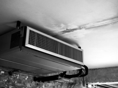 Black machine, modern air conditioning ceiling mounted ventilation system decoration on ceiling in old white construction building factory, loft style interior, black and white style. clipart