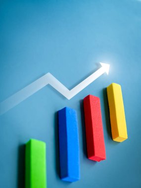 Dikey çokrenkli bloktaki yükselen ok mavi arkaplan üzerinde bir iş grafiği, minimal tarz, yakın çekim olarak yapışıyor. İş hedefi ve başarı, kâr, gelir, büyüme pazarlaması ve eğilim kavramları.