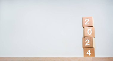 2024 Mutlu Yıllar arkaplan afişi. İki bin yirmi üç yıllık tahta küpler üzerinde beyaz arka planda fotokopi alanı olan rakamlar. Hoş geldiniz, Mutlu Noeller ve 2024 yılının kutlu olsun..