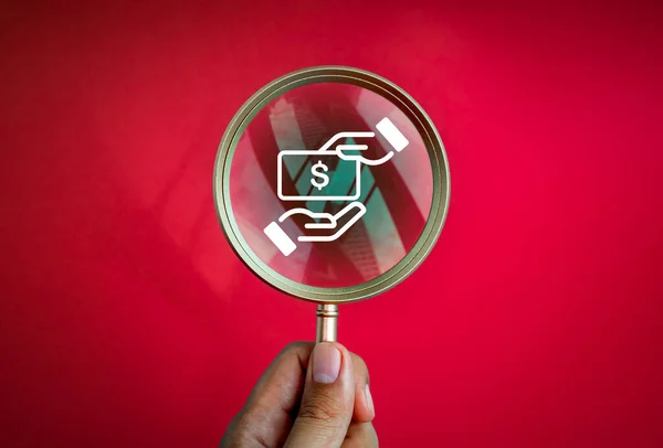 Searching, stop corruption and anti corrupt concept. Corruption icon in a luxury gold magnifying glass in people\'s hands isolated on red background, minimal style. Found hidden illegal act.